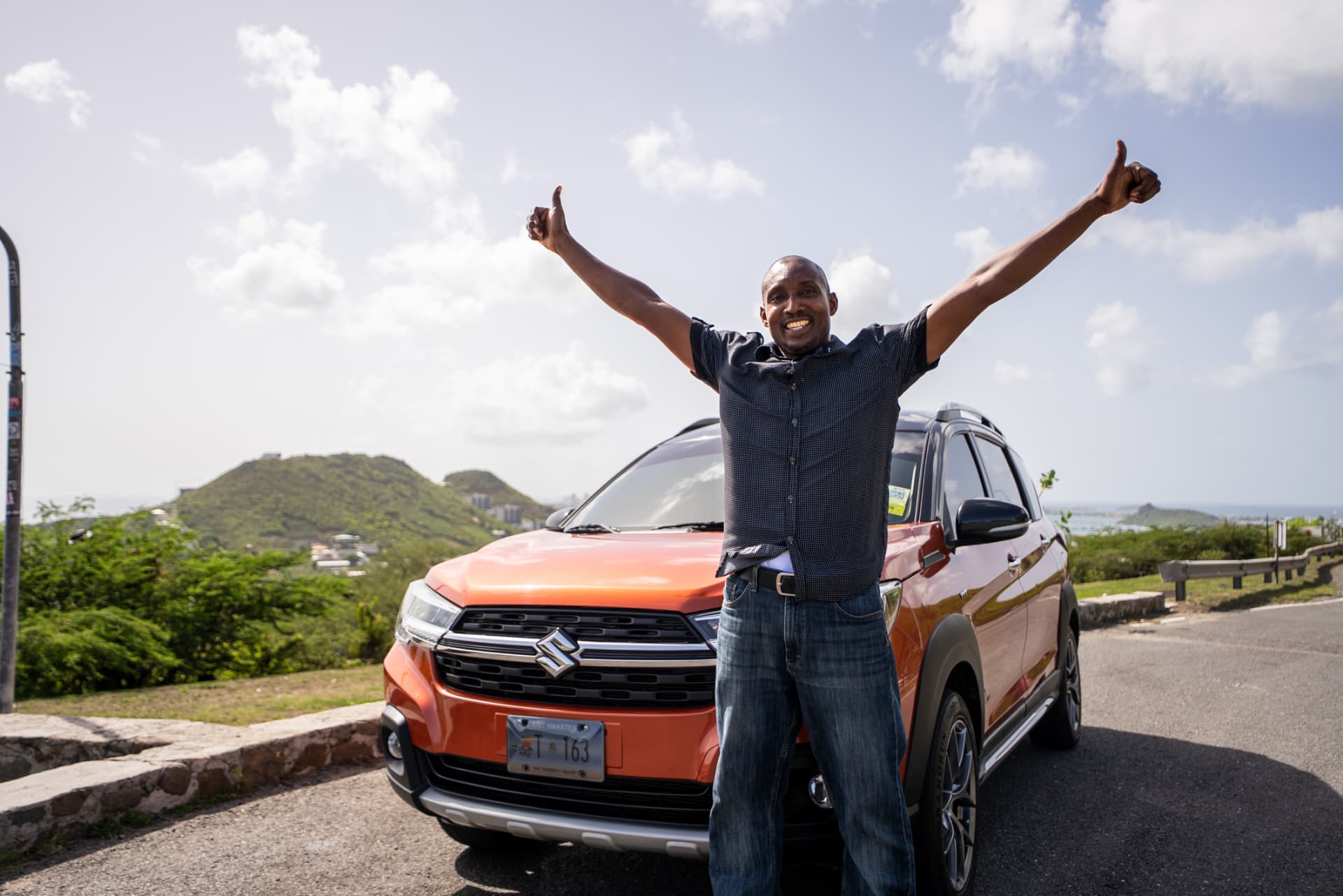 Nature Tours driver next to the orange Suzuki XL7